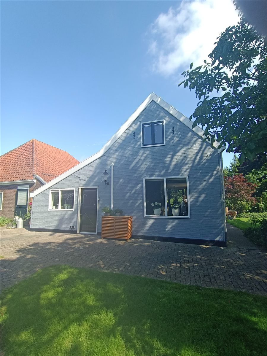 Moderne woning met lichtgrijze geschilderde gevel en witte kozijnen