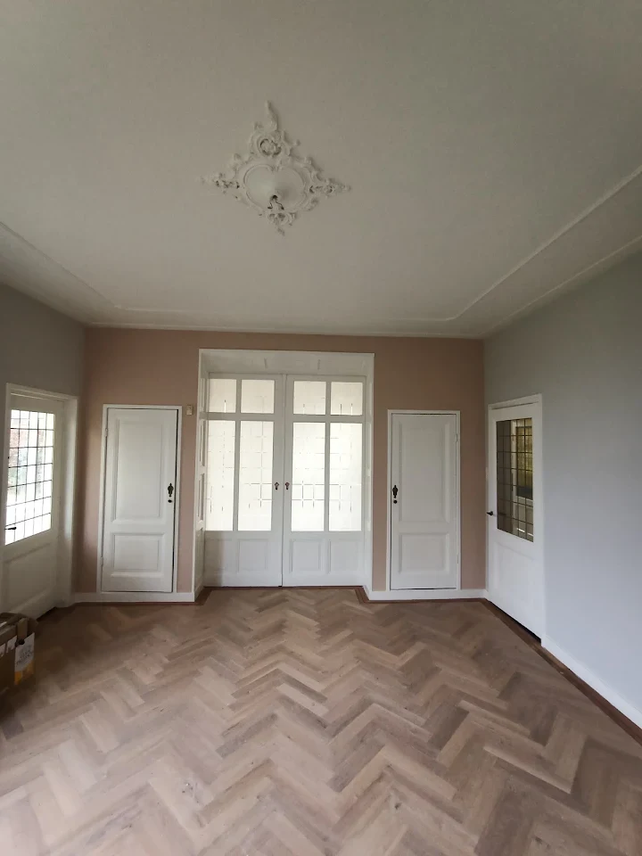 Kamer met roze muren en ornament plafond